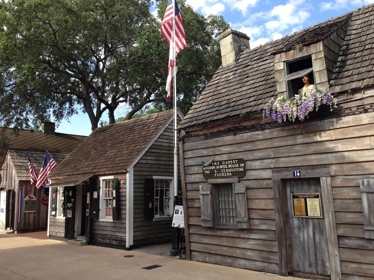 Wooden façade of the Genopoly House on St. George Street, with its Oldest Wooden School House sign.
